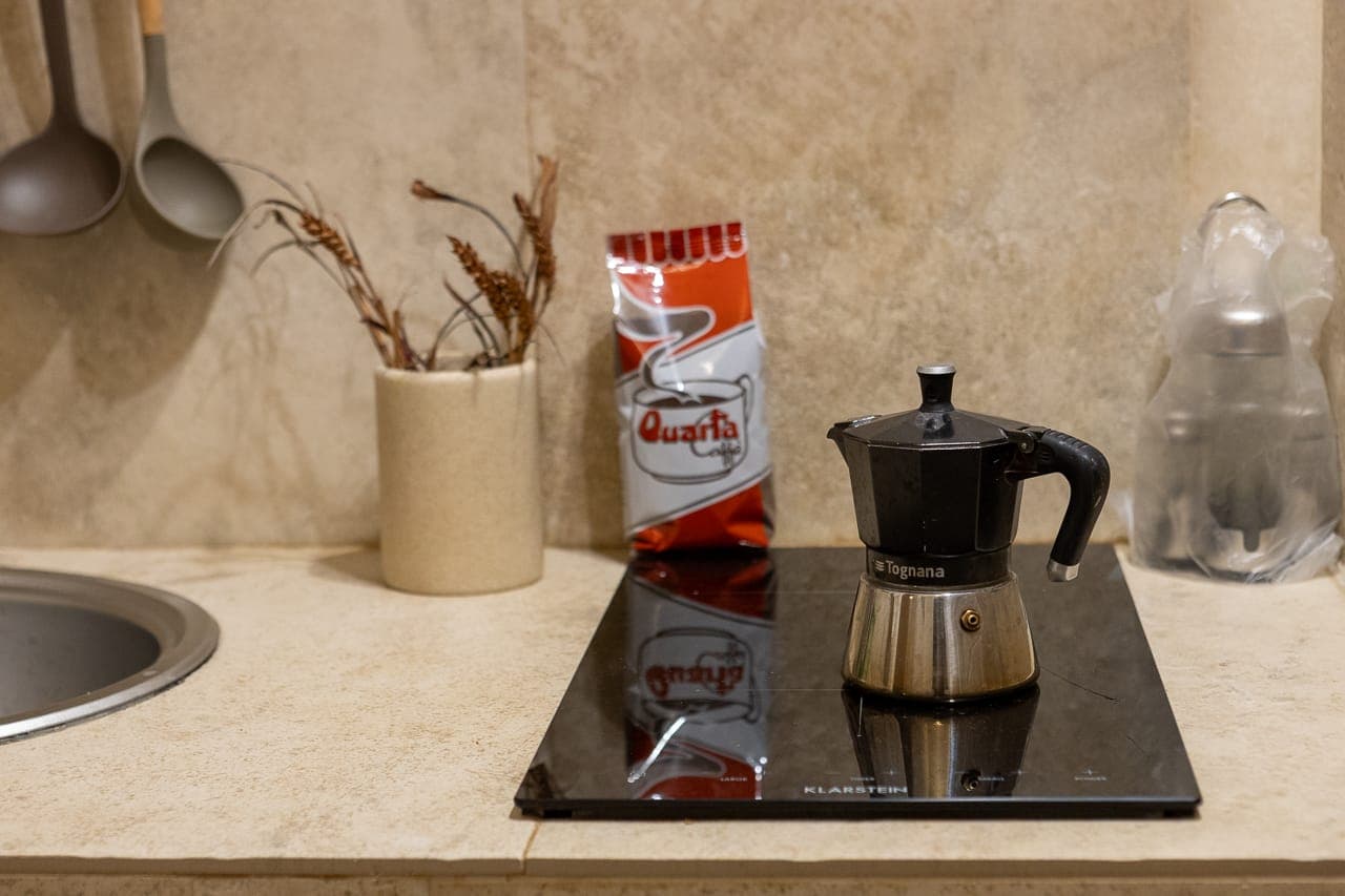 Angolo cucina con moka sul piano a induzione e caffè salentino